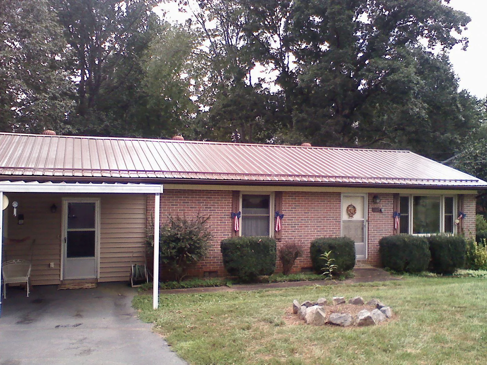 Bronze metal roof and carport on a brick ranch home — Roof Repair work by our crew in Duluth
